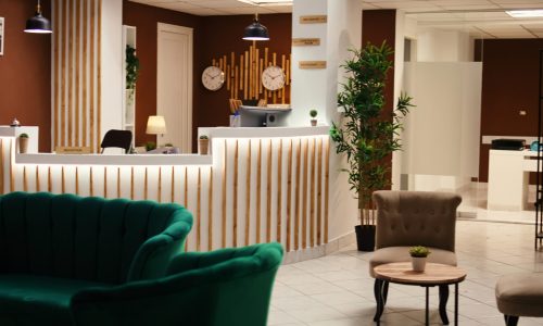 Wide angle shot of hotel lounge Wide angle shot of travel accommodation hotel lounge with check in reception desk. Stylish empty modern resort foyer interior with cozy furniture and warm fireplace ready to welcome tourists